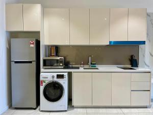 una cocina con lavadora y microondas en Quill Comport Suits KLCC, en Kuala Lumpur