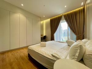 Un dormitorio con una gran cama blanca con ventana. en Quill Comport Suits KLCC, en Kuala Lumpur