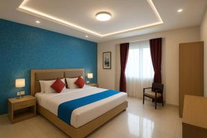 een slaapkamer met een groot bed met een blauwe muur bij VIP Hotel Residency Puri Inn - Top-Rated Luxury Hotel - Near Sea Beach & Sea Facing Rooms In Puri - AC Rooms #Lift - Free Wi-Fi & Parking - A Best Luxury Hotel Inn Puri Book Now in Puri