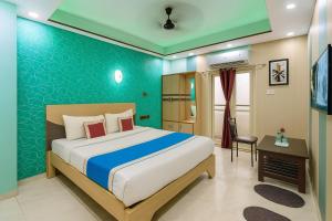een slaapkamer met een bed en een bureau in een kamer bij VIP Hotel Residency Puri Inn - Top-Rated Luxury Hotel - Near Sea Beach & Sea Facing Rooms In Puri - AC Rooms #Lift - Free Wi-Fi & Parking - A Best Luxury Hotel Inn Puri Book Now in Puri