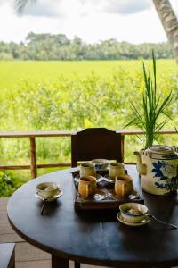 - une table avec un plateau de nourriture et un vase dans l'établissement Thala Tra Vinh, à Trà Vinh