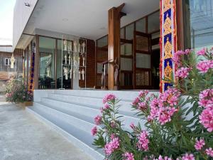 a building with pink flowers in front of it at Chiangdaoinnhotel โรงแรมเชียงดาวอินน์ in Chiang Dao