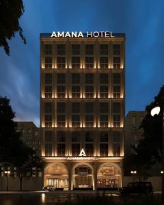 a building with a amana hotel lit up at night at AMANA Hotel Phan Thiet in Ấp Bình Hưng
