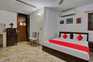 a bedroom with a bed and a table and a chair at Hotel O by OYO TSA in New Delhi