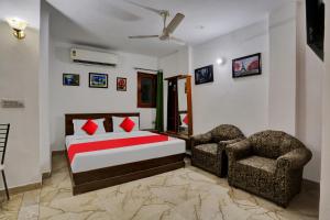a bedroom with a bed and two chairs at Hotel O by OYO TSA in New Delhi +31 photos