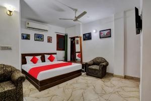 a bedroom with a bed and two chairs at Hotel O by OYO TSA in New Delhi