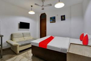 a bedroom with a bed and a couch and a tv at Hotel O by OYO TSA in New Delhi