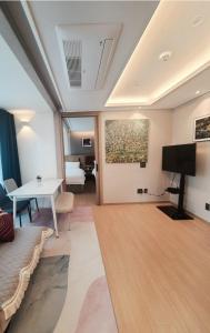 a living room with a table and a painting on the wall at 해운대호텔 엘본더스테이 in Busan