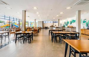 ein Restaurant mit Tischen und Stühlen und ein Spielplatz in der Unterkunft Solar Pedra da Ilha in Penha