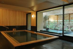 a swimming pool in a room with a large window at Iwaso in Miyajima