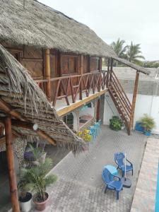 a resort with a thatched roof and chairs and tables at Hostal Villa Brisa in Ballenita +112 photos