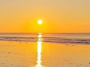 a sunset on a beach with the ocean at 5 person holiday home in Henne-By Traum in Henne Strand +44 photos