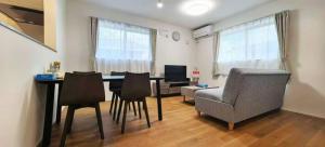 een woonkamer met een eettafel en stoelen bij KamakurakoshigoeekimaeA in Kamakura