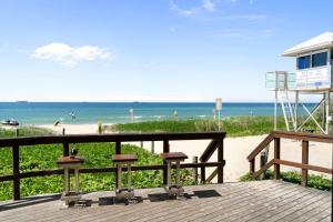 a wooden deck with a view of the beach at Casa Oasis Beachfront at Bokarina in Bokarina