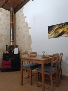 a wooden table with chairs and a painting on the wall at Etna Garden Francesca in Presa