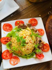 a plate of food with rice and tomatoes on a table at An Homestay Tam Coc in Ninh Binh +30 photos