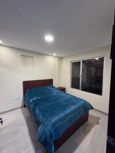 ein Schlafzimmer mit einem Bett und einem großen Fenster in der Unterkunft casa en cuenca full equipada in Cuenca