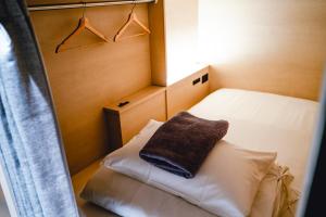 a small room with a bed with a pillow on it at UNPLAN Kagurazaka in Tokyo