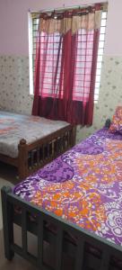 a bedroom with two beds and a window at Happy Tourist Home Neyyardam in Parattipalli