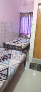 two beds in a room with purple curtains at Happy Tourist Home Neyyardam in Parattipalli