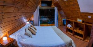 Un dormitorio con una cama en una cabaña de troncos en GLAMPING CACHI EL PARAISO DE NALA, en Cachí