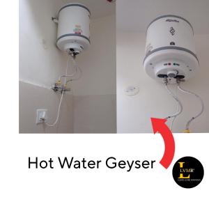 ein Badezimmer mit einer Warmwasserboiler-Leuchte an der Wand in der Unterkunft LVMR Midtown Homestay in Kulu