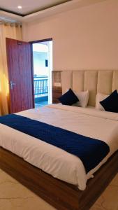 a bedroom with a large bed with blue pillows at Hotel shivansh Residency in Rishīkesh