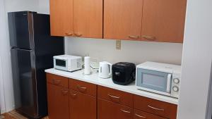 een keuken met een magnetron en een koelkast bij 唐比ステイ in Isahaya