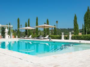 a swimming pool with two umbrellas and chairs at Relais Sassa al Sole in San Miniato