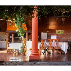 ein Tisch mit Stühlen und einer Stange in einem Restaurant in der Unterkunft Hostal Villa Verde in Asunción