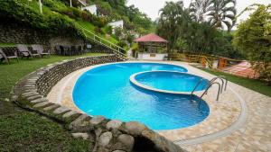 a large blue swimming pool in a yard at Fundo San Jose Parque Ecológico & Lodge Hotel Asociado Casa Andina in La Merced