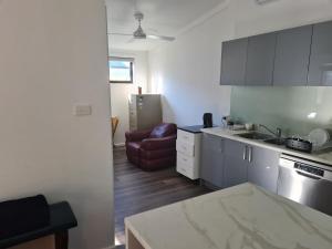 a kitchen with a sink and a couch in a room at Fully Self Contained Guesthouse Retreat in Fishing Point