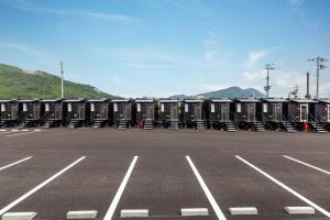 eine Reihe tragbarer Toiletten auf einem Parkplatz in der Unterkunft HOTEL R9 The Yard Tagawakawara 