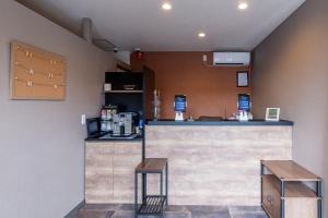 ein Restaurant mit einer Theke und zwei Hockern in der Unterkunft HOTEL R9 The Yard Tagawakawara  + 16 Fotos