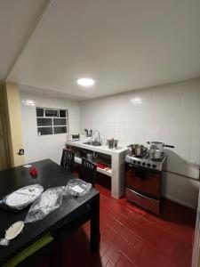 Una cocina con una mesa, una estufa y un fregadero. en The Mountain Apto House, en Bogotá