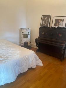 a bedroom with a bed and a dresser and a piano at Maison Chez Grand-mère, Route des vins in Bergheim
