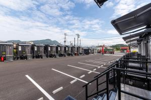 ein Parkplatz mit einer Reihe winziger Häuser in der Unterkunft HOTEL R9 The Yard Tagawakawara 