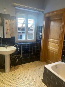 a bathroom with a sink and a tub and a window at Maison Chez Grand-mère, Route des vins in Bergheim