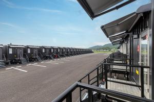 eine Reihe von Zugautos auf einem Parkplatz in der Unterkunft HOTEL R9 The Yard Tagawakawara 