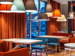 a restaurant with tables and chairs and lights at ibis Styles Szczecin Stare Miasto in Szczecin