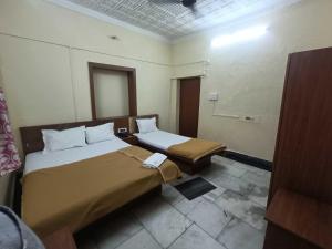 a room with two beds in a hotel room at Hotel O Down Town Hotel in Calcutta Bara Bazar