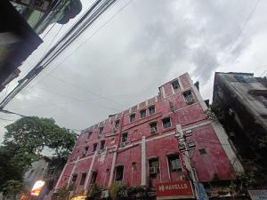 a red brick building on the side of a street at Hotel O Down Town Hotel in Calcutta Bara Bazar