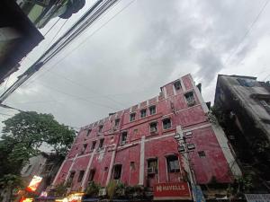 a red building on the side of a street at Hotel O Down Town Hotel in Calcutta Bara Bazar
