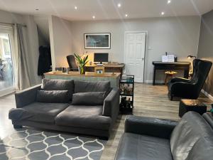 a living room with a couch and a piano at Spacious 2 & 3 Bed Ribble Valley Apartments in Blackburn