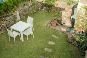 a white table and chairs on the grass at Aewol Handamgil Stay in Jeju