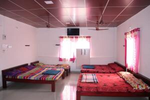 埃尔加德Sai Ram Homestay - Near Yercaud Lake的一间设有三张床和一台电视的房间 更多9张照片