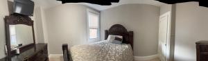 a bedroom with a bed and a tv and a window at Kelly Lodging in Baltimore