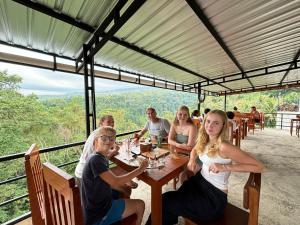 a group of people sitting at a table in a restaurant at Dragonfly Senaru Lodge in Senaru