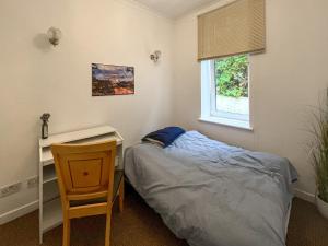 a bedroom with a bed and a desk and a chair at Lochside Hermitage in Rashfield +4 photos