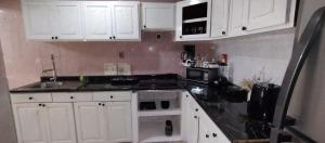 a kitchen with white cabinets and a sink and a microwave at The Room Veracruz, super location in Veracruz